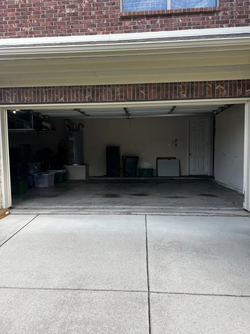 Open garage with cleared floor and storage along the back wall