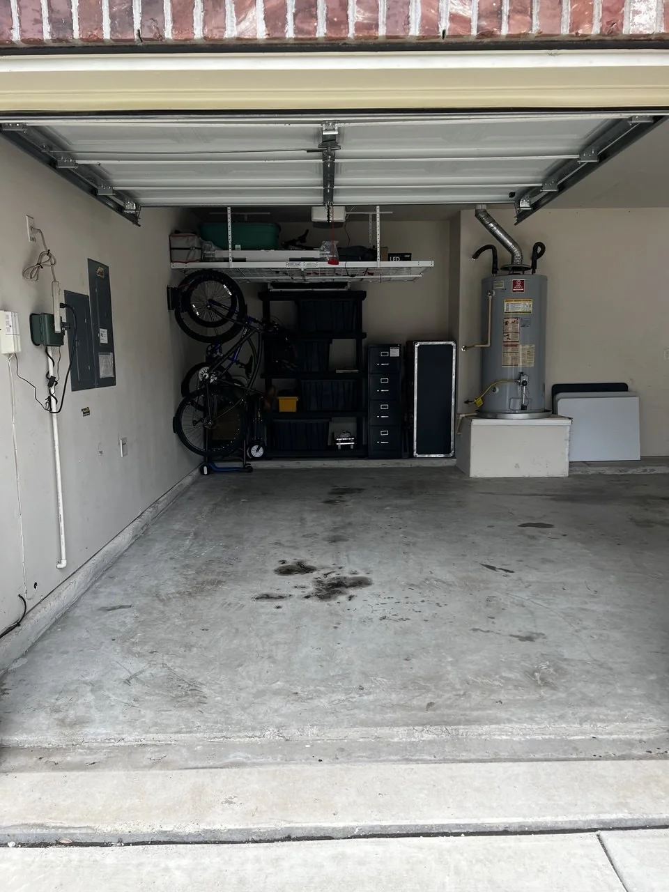 Garage storage wall with bikes, shelving, bins, and clear floor space
